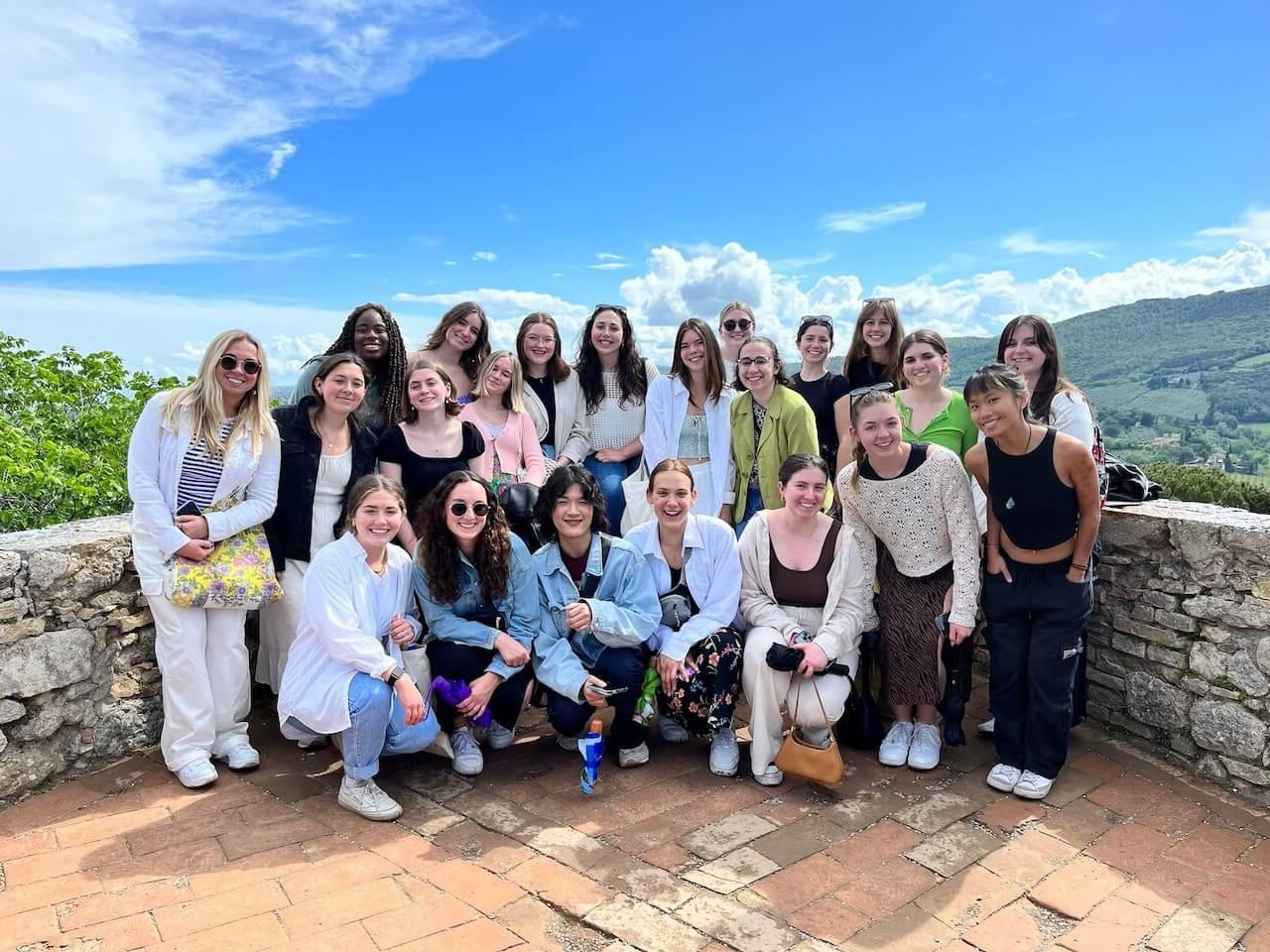 A big group of students standing and smiling together in San Gimignano, Italy